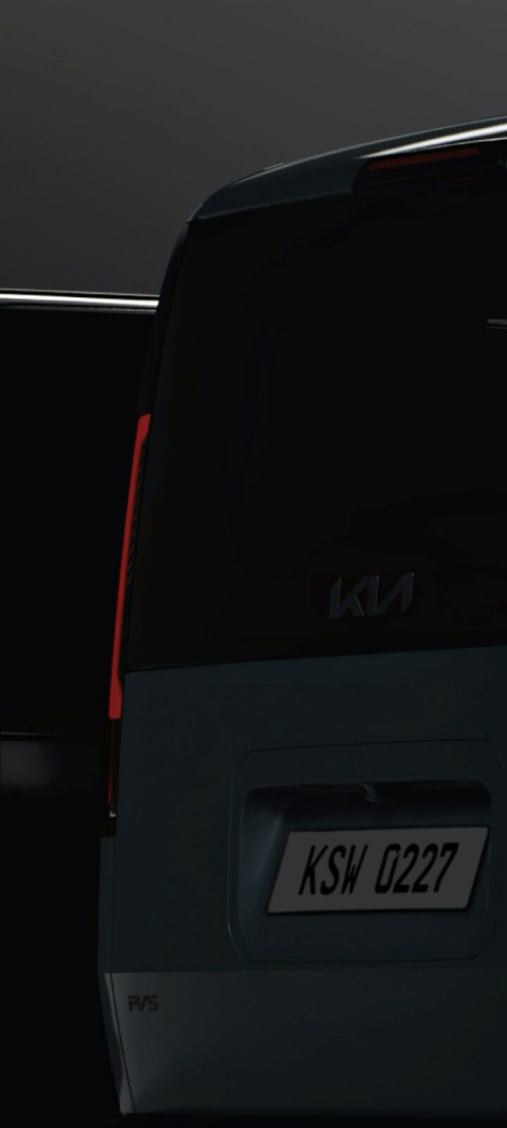 Heckansicht des Kia PV5 Passenger bei schwachem Licht – die Rückleuchten stehen im Fokus.